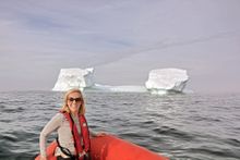 Lyndsey in Newfoundland, Canada with a small iceberg in the background