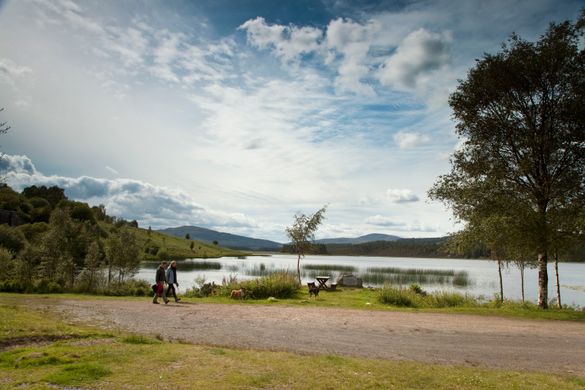 A couple walking by Stroan Loch on the Raiders Road Forest Drive in the Galloway Forest Park, Dumfries and Galloway A couple walking by Stroan Loch on the Raiders Road Forest Drive in the Galloway Forest Park, Dumfries and Galloway