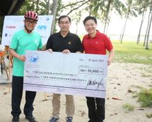 The Travel Corporation Asia President Mr Robin Yap (L) and Singapore's Minister for National Development Mr Lawrence Wong (R)  jointly presented a cheque of ,000 raised for the event to to Mr Arthur Ling, Director, Fei Yue Community Services (Centre)