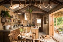 Rustic open-plan kitchen with double barn doors opening onto the front deck