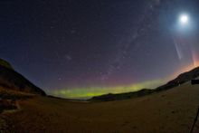 The Aurora Australis lights up Dunedin skies on a full moon night in New Zealand. 
