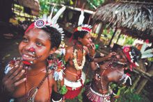 Face paint preparations for these Trobriand Islanders at the Kenu and Kundu Festival, in Alotau