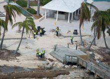 Workers clear seaweed from a beach at the Casa Marina Resort in Key West, Fla., Tuesday, Sept. 19,. 2017. Workers around the 125-mile island chain are to make repairs and clean up from impacts caused by the tropical cyclone