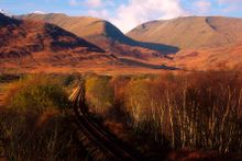 Looking along a single track section of the West Highland Line to Oban as it passes through autumnal countryside near Dalmally, Argyll & Bute