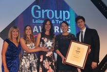 (L-R) Maureen Quinn of 'Just for Groups!' presents Sophie Thomas, Sales Executive – Groups, Hayley Walker, Sales Assistant – Groups and Ellie Fulcher, Sales Manager – Groups with the trophy alongside special guest and co-host, Magician Ben Hanlin.