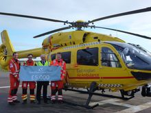 The crew of the East Anglian Air Ambulance receive the Fred. Olsen Social Engagement Group's donation of £5,000 from Mike Rodwell, Fred. Olsen Cruise Lines' Managing Director (2nd from right), at its airbase at Cambridge Airport.