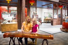 Playing Chinese instrument in Take Me There: China