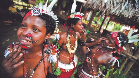 Face paint preparations for these Trobriand Islanders at the Kenu and Kundu Festival, in Alotau